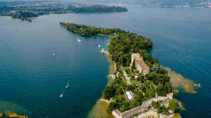 Captivating aerial shot of an island with a historic castle, surrounded by lush greenery and serene waters., tags: tranquilli - pexel